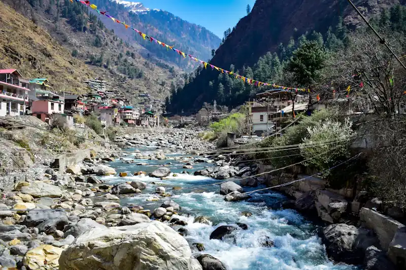 A stream and houses on a mountain slope.