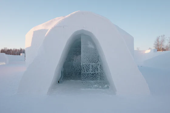 A snow igloo with a lit window